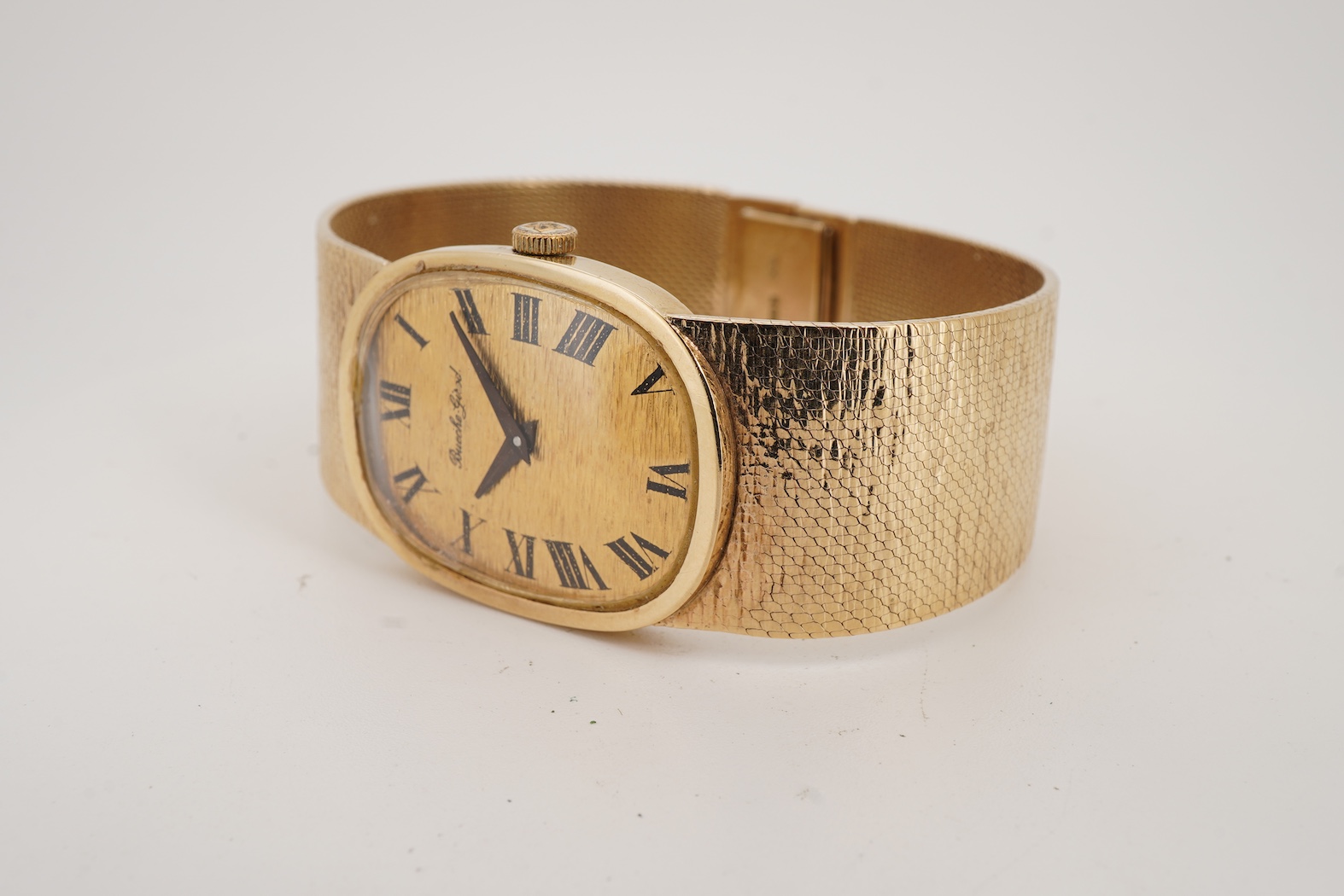 A gentleman's early 1970's 9ct gold Bueche Girod manual wind dress wrist watch, on an integral 9ct gold bark effect bracelet